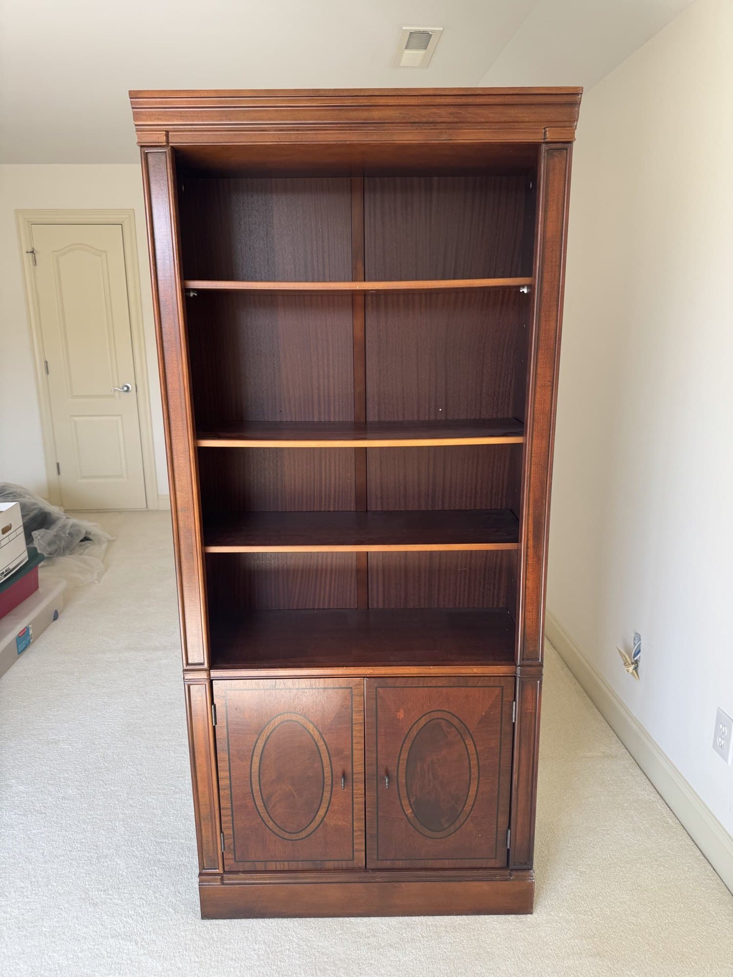 Inlaid mahogany bookcase with reeded pilasters, oval string inlay and its lower doors closed, photographed for the VaultXL listing